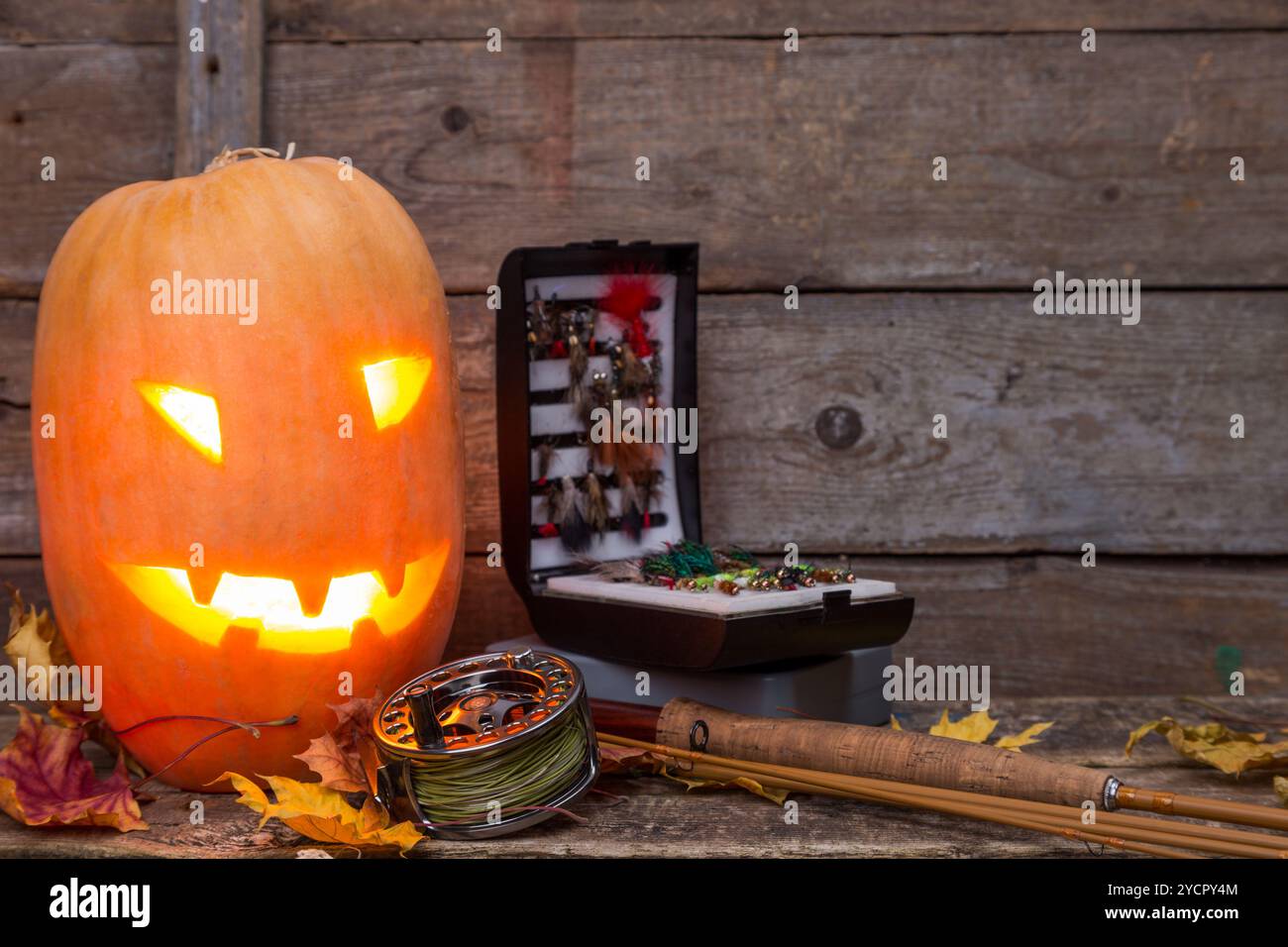 Tête de citrouille d'Halloween avec tacles de pêche à la mouche Banque D'Images Tête de citrouille d'Halloween avec tacles de pêche à la mouche Banque D'Images