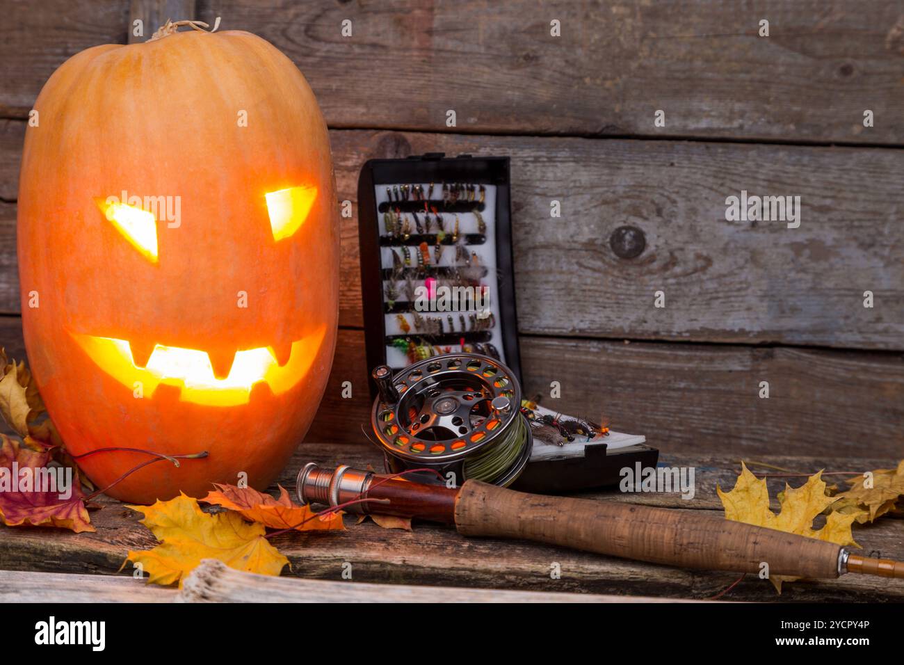 Tête de citrouille d'Halloween avec tacles de pêche à la mouche Banque D'Images Tête de citrouille d'Halloween avec tacles de pêche à la mouche Banque D'Images