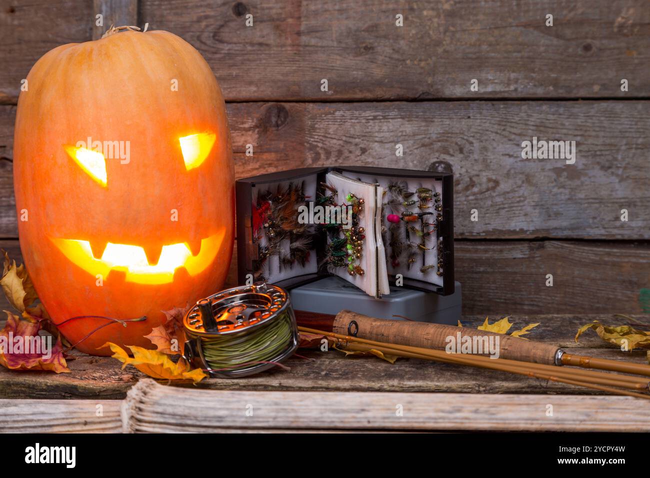Tête de citrouille d'Halloween avec tacles de pêche à la mouche Banque D'Images Tête de citrouille d'Halloween avec tacles de pêche à la mouche Banque D'Images