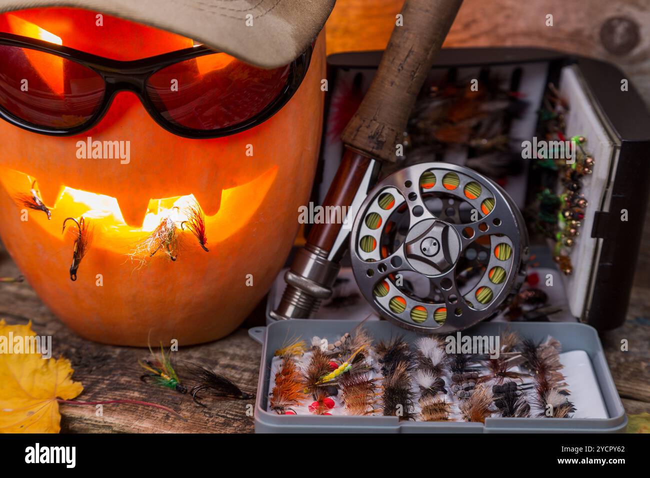 Citrouille d'Halloween dans un chapeau avec des tacles de pêche à la mouche Banque D'Images Citrouille d'Halloween dans un chapeau avec des tacles de pêche à la mouche Banque D'Images