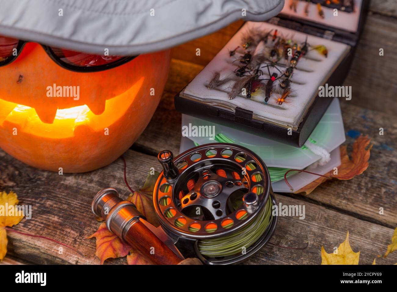 Citrouille d'Halloween dans un chapeau avec des tacles de pêche à la mouche Banque D'Images Citrouille d'Halloween dans un chapeau avec des tacles de pêche à la mouche Banque D'Images