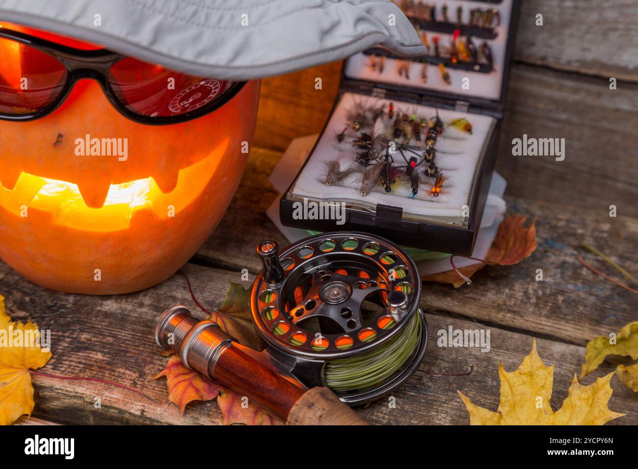 Citrouille d'Halloween dans un chapeau avec des tacles de pêche à la mouche Banque D'Images Citrouille d'Halloween dans un chapeau avec des tacles de pêche à la mouche Banque D'Images