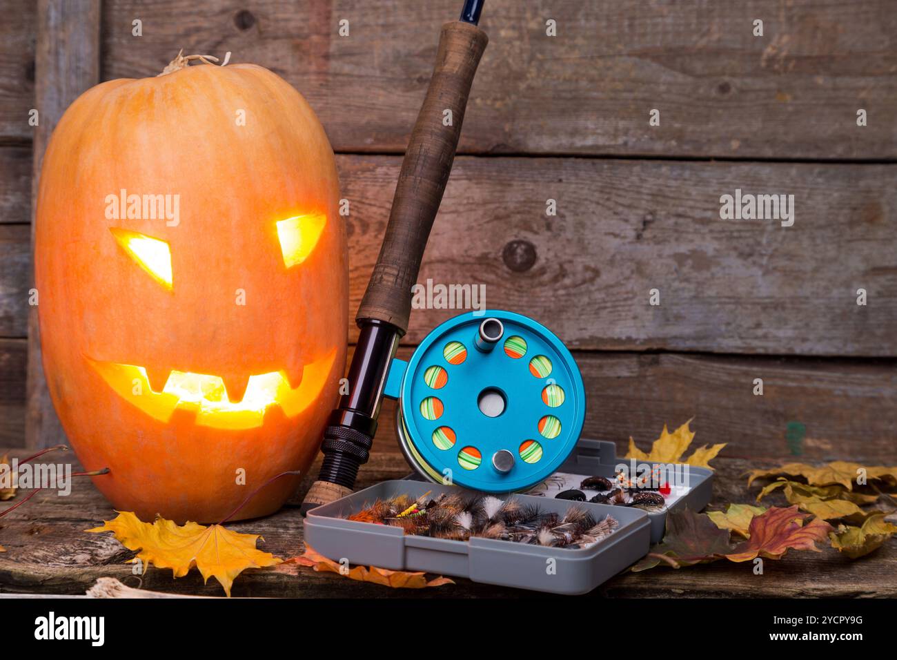 Tête de citrouille d'Halloween avec tacles de pêche à la mouche Banque D'Images Tête de citrouille d'Halloween avec tacles de pêche à la mouche Banque D'Images
