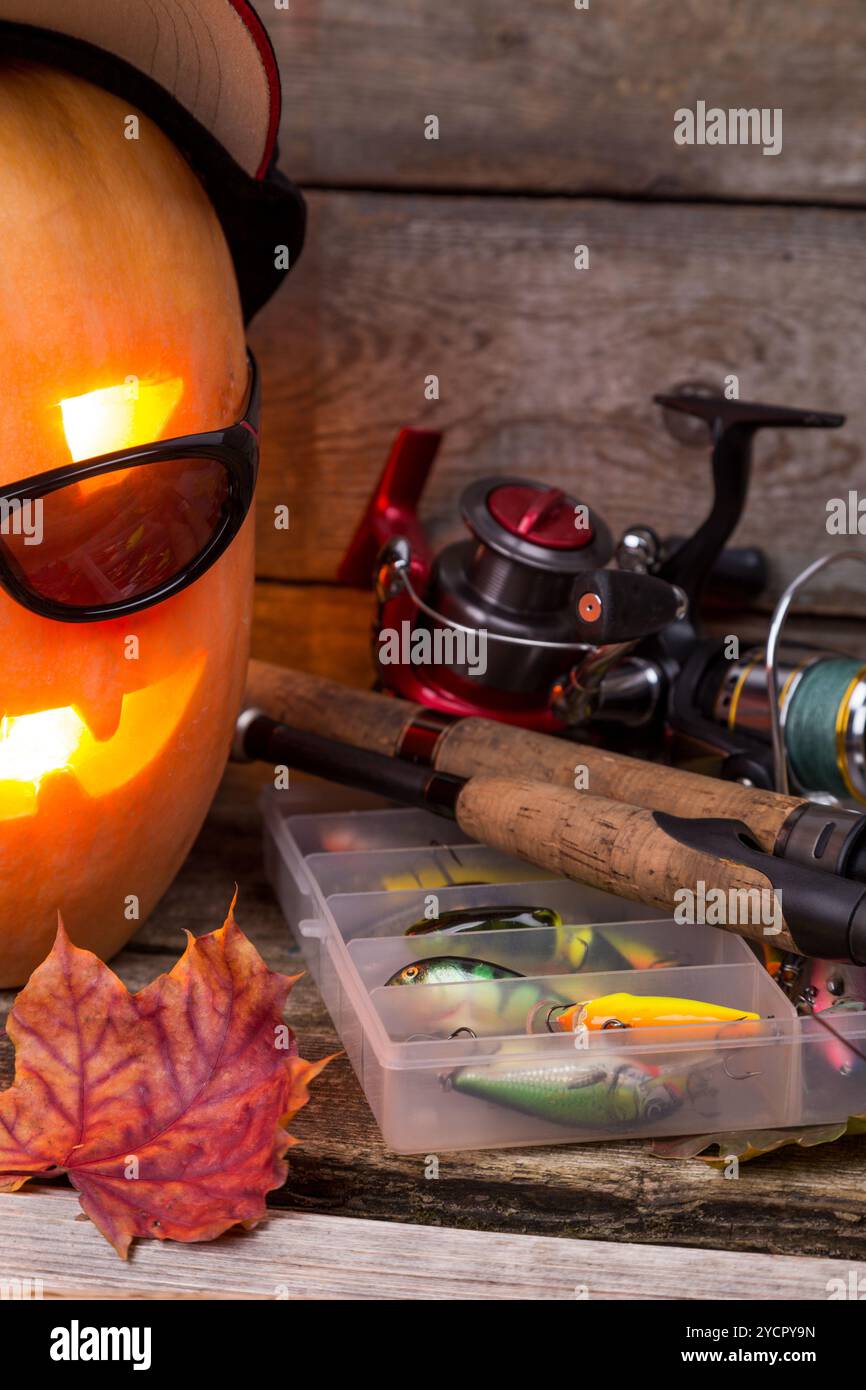 Citrouille d'Halloween en chapeau avec des tacles de pêche Banque D'Images Citrouille d'Halloween en chapeau avec des tacles de pêche Banque D'Images