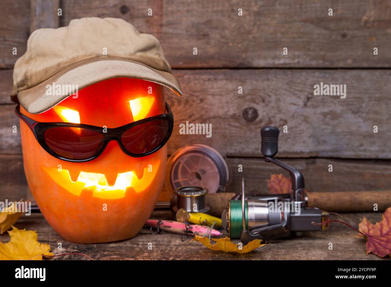 Citrouille d'Halloween en chapeau avec des tacles de pêche Banque D'Images Citrouille d'Halloween en chapeau avec des tacles de pêche Banque D'Images