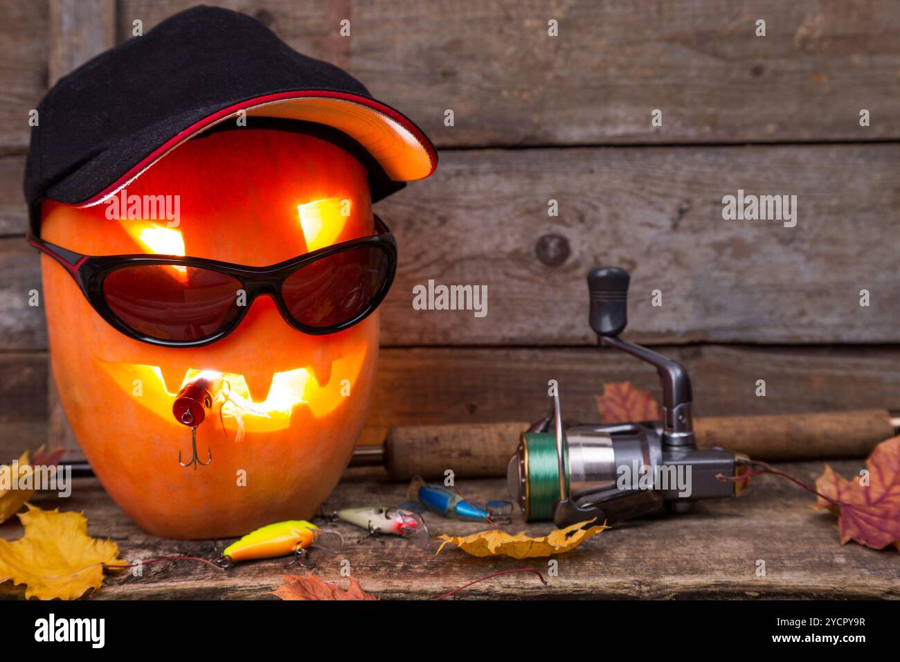 Citrouille d'Halloween en chapeau avec des tacles de pêche Banque D'Images Citrouille d'Halloween en chapeau avec des tacles de pêche Banque D'Images