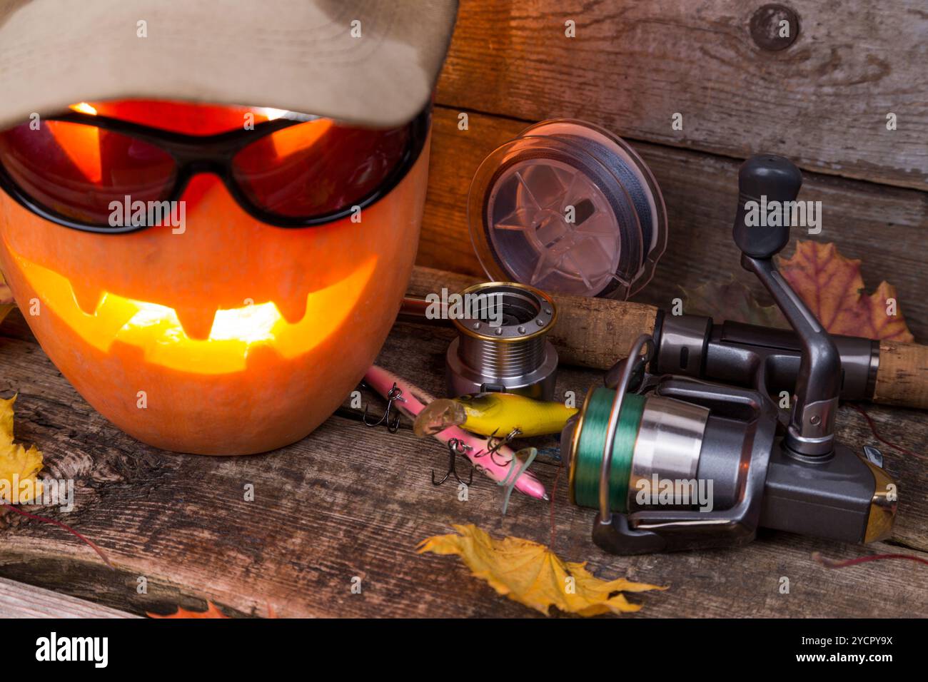 Citrouille d'Halloween en chapeau avec des tacles de pêche Banque D'Images Citrouille d'Halloween en chapeau avec des tacles de pêche Banque D'Images