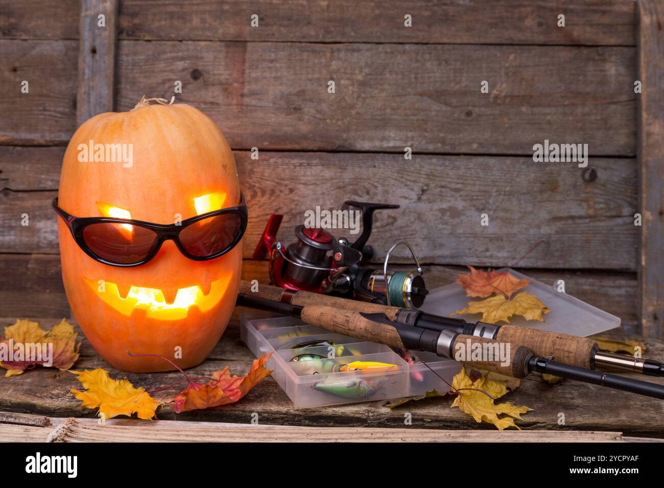 Citrouille d'Halloween dans des lunettes avec des tacles de pêche Banque D'Images Citrouille d'Halloween dans des lunettes avec des tacles de pêche Banque D'Images