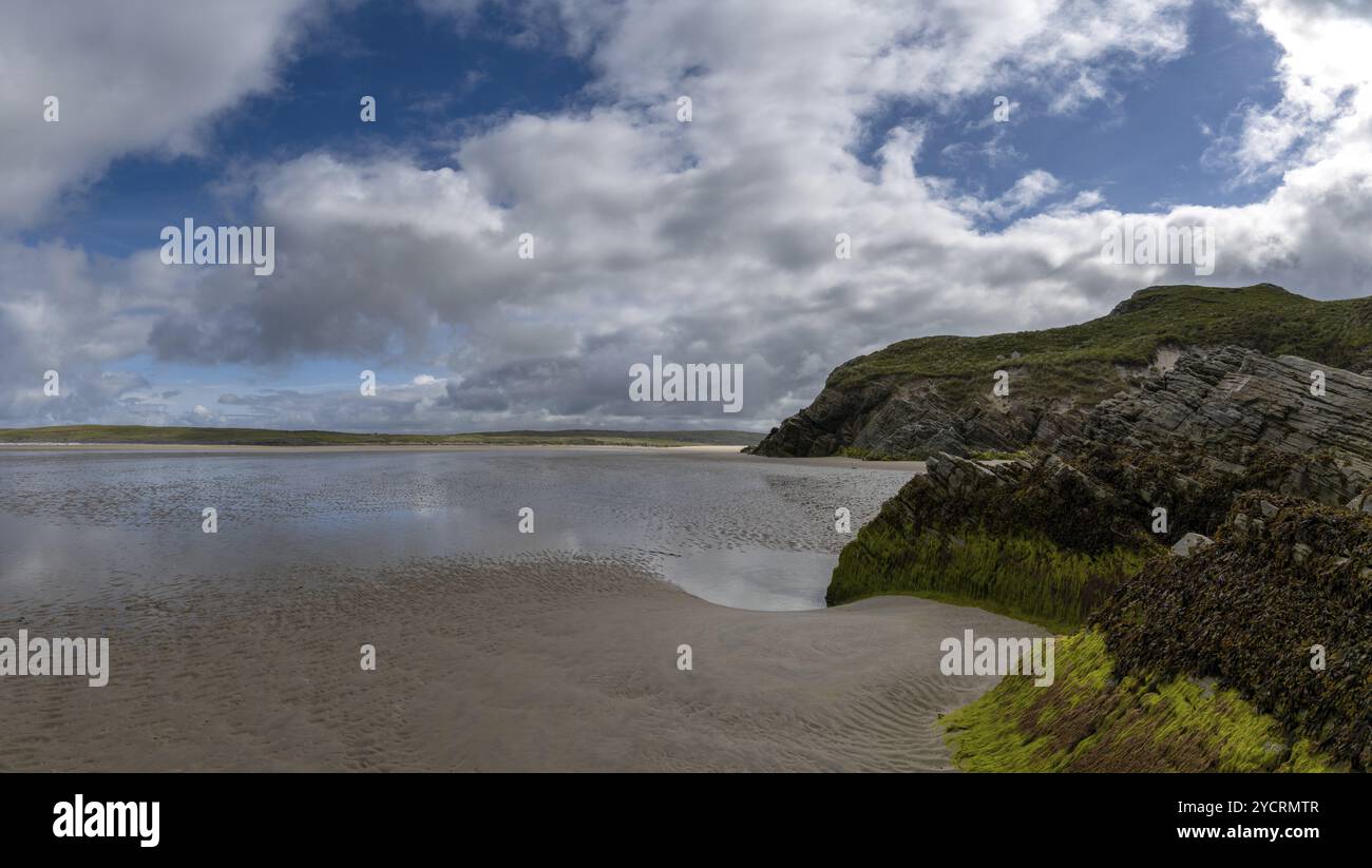 Vue sur la pittoresque plage de sable doré de Maghera avec des rochers et des falaises recouverts d'algues au premier plan Banque D'Images