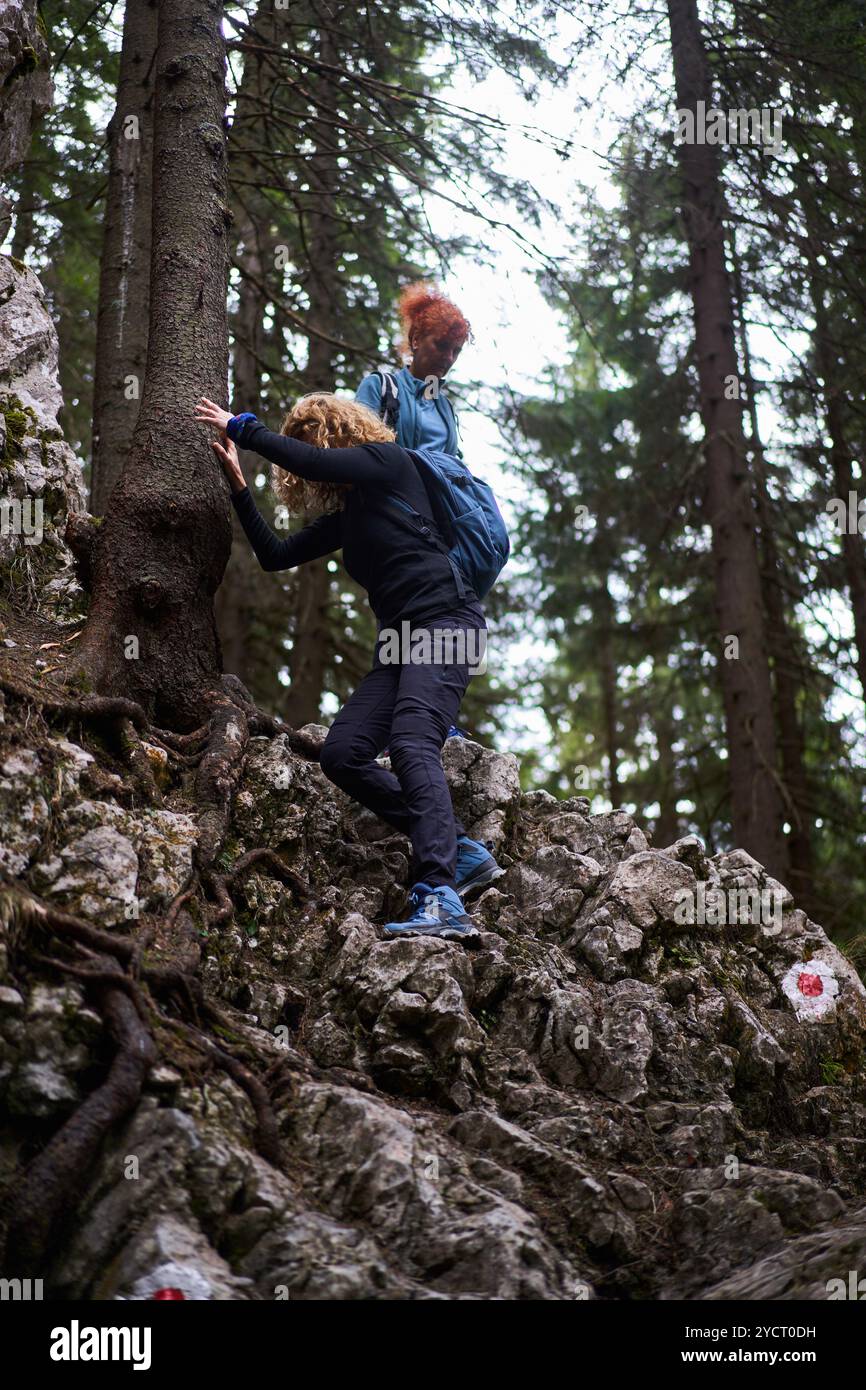 Femmes avec des sacs à dos randonnée sur un sentier dans les montagnes Banque D'Images