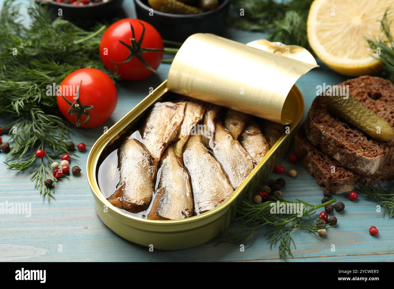 De savoureux sprats en boîte peuvent être servis sur une table en bois bleu clair, gros plan Banque D'Images