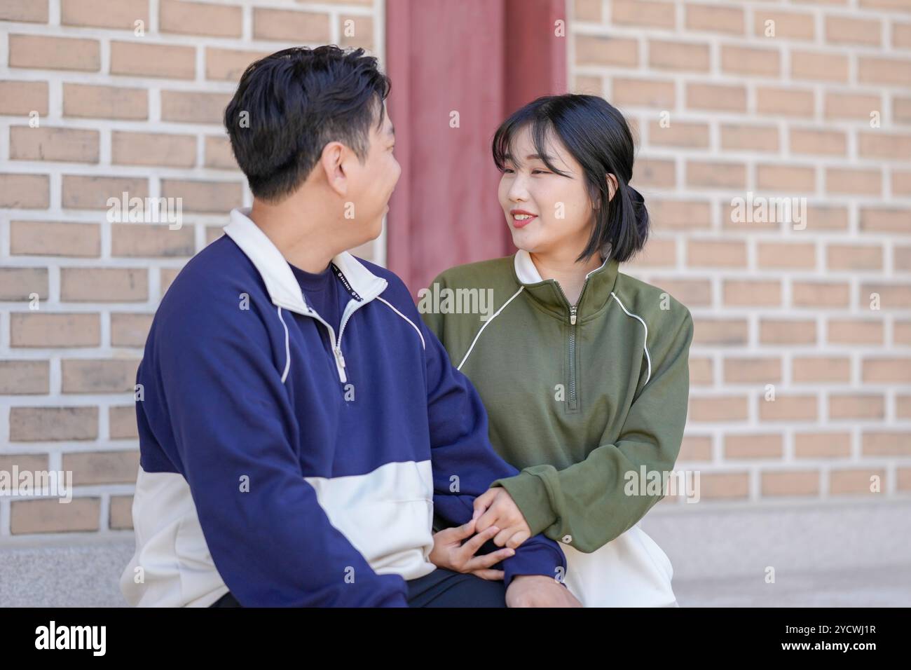 Un couple coréen sportif, un homme dans les années 30 et une femme dans les années 20, portant des survêtements, passe leur temps ensemble heureux dans un bâtiment historique en se Banque D'Images