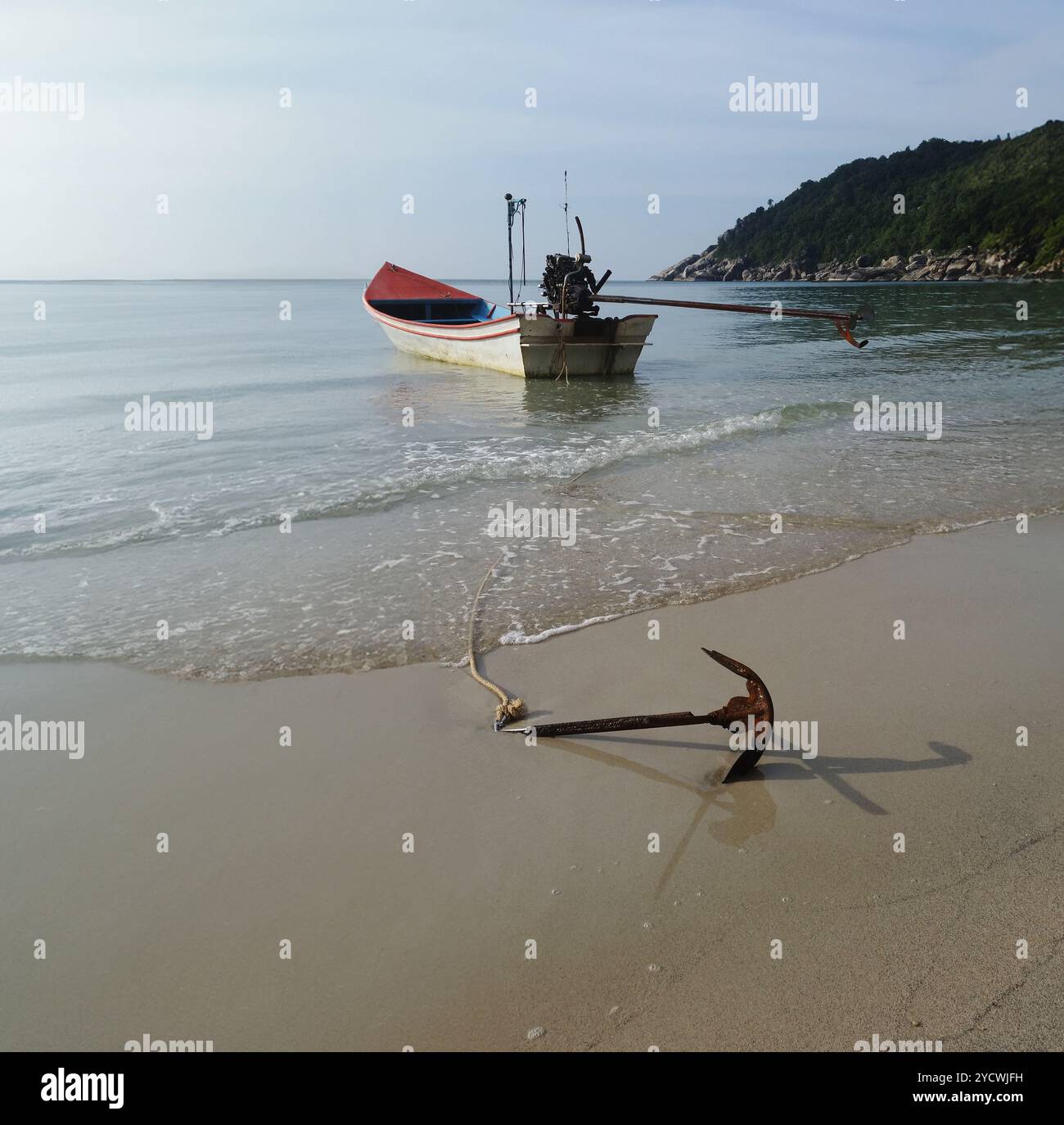 Bateau ancré dans l'océan avec ancre sur le sable, ancré à la terre, bateau océanique et montagnes, vie insulaire tropicale Banque D'Images