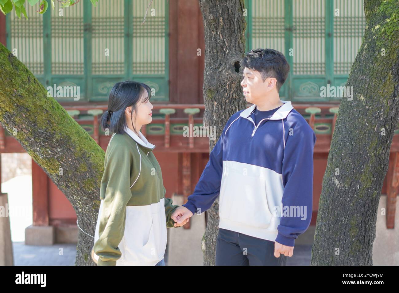 Un couple coréen sportif, un homme dans les années 30 et une femme dans les années 20, portant des survêtements, passe leur temps ensemble heureux dans un bâtiment historique en se Banque D'Images