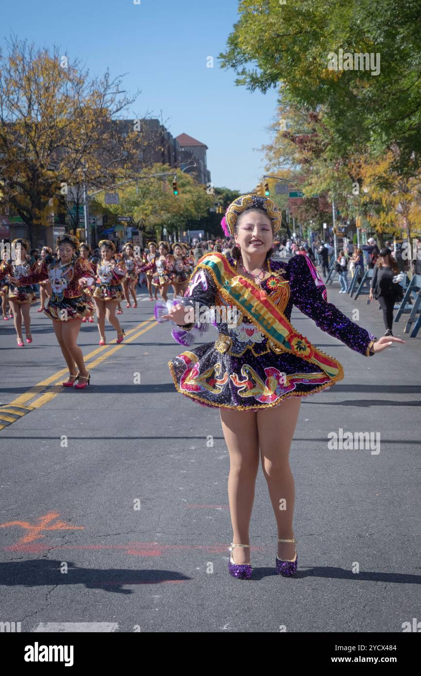 Une danseuse heureuse de la troupe San Simon danse et marche au défilé de la Journée bolivienne 2024 à Jackson Heights, Queens, New York. Banque D'Images