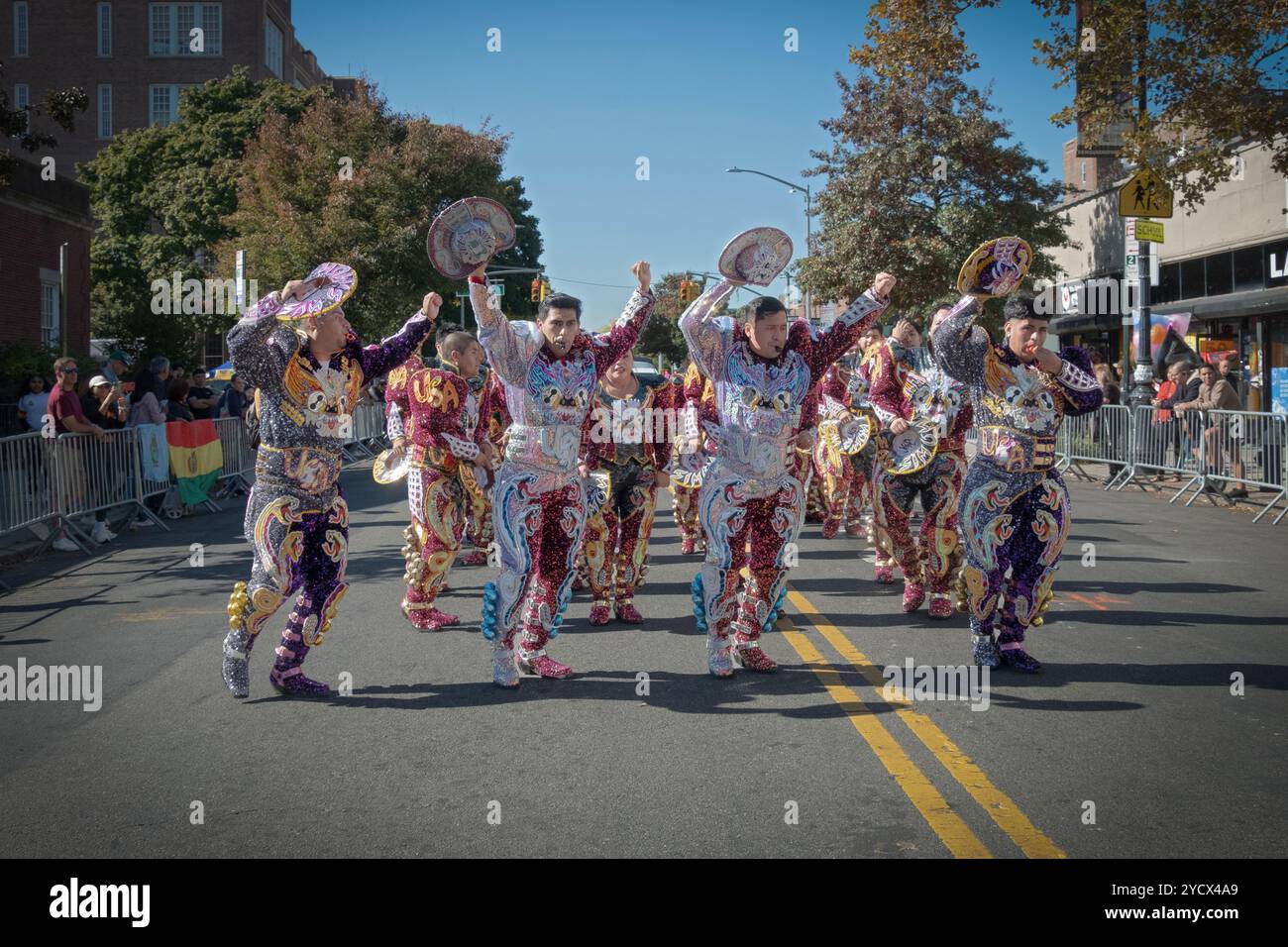 Les hommes du groupe de danse bolivien San Simon lèvent leurs chapeaux en dansant et marchant sur la 37e avenue lors du défilé de la fête bolivienne 2024 dans le Queens, New York. Banque D'Images