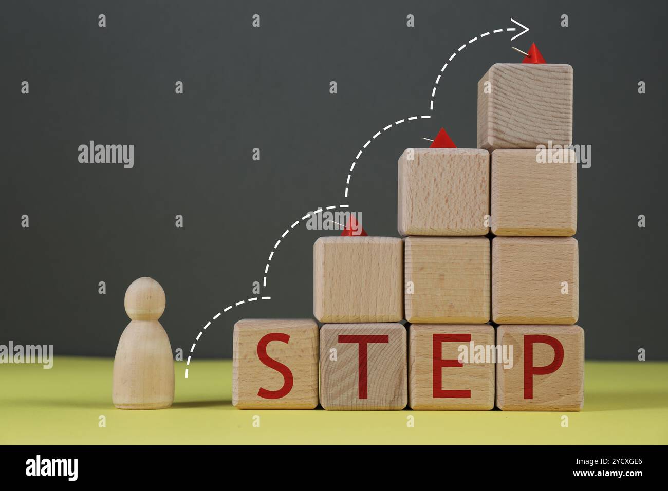 Figure humaine devant l'escalier de cubes en bois avec des épingles et le mot Step sur la table jaune. Flèche indiquant la direction. Concept étape par étape Banque D'Images