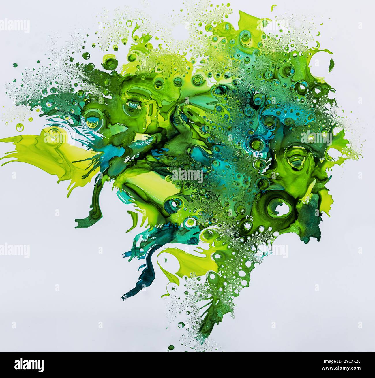 Une explosion dynamique de gouttes d'encre verte et bleue se dispersant dans l'eau, créant un motif abstrait et artistique avec des effets tourbillonnants et bouillonnants Banque D'Images