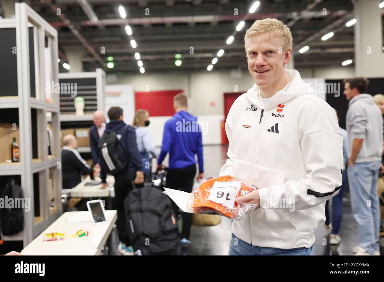 Nuremberg, Allemagne. 24 octobre 2024. Habiller les athlètes de la DSV (Association allemande de ski) biathlète Roman Rees tient son paquet de casquettes dans sa main lors de la cérémonie officielle d'habillage de l'Association allemande de ski (DSV) avant le début de la saison dans le hall d'exposition. Crédit : Daniel Löb/dpa/Alamy Live News Banque D'Images