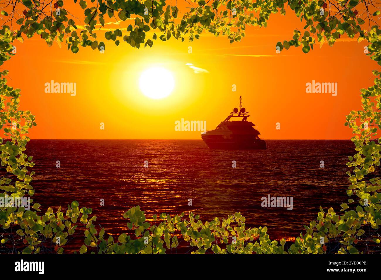 Yacht de luxe sur la mer ouverte au coucher du soleil doré vue à travers le cadre de feuilles Banque D'Images