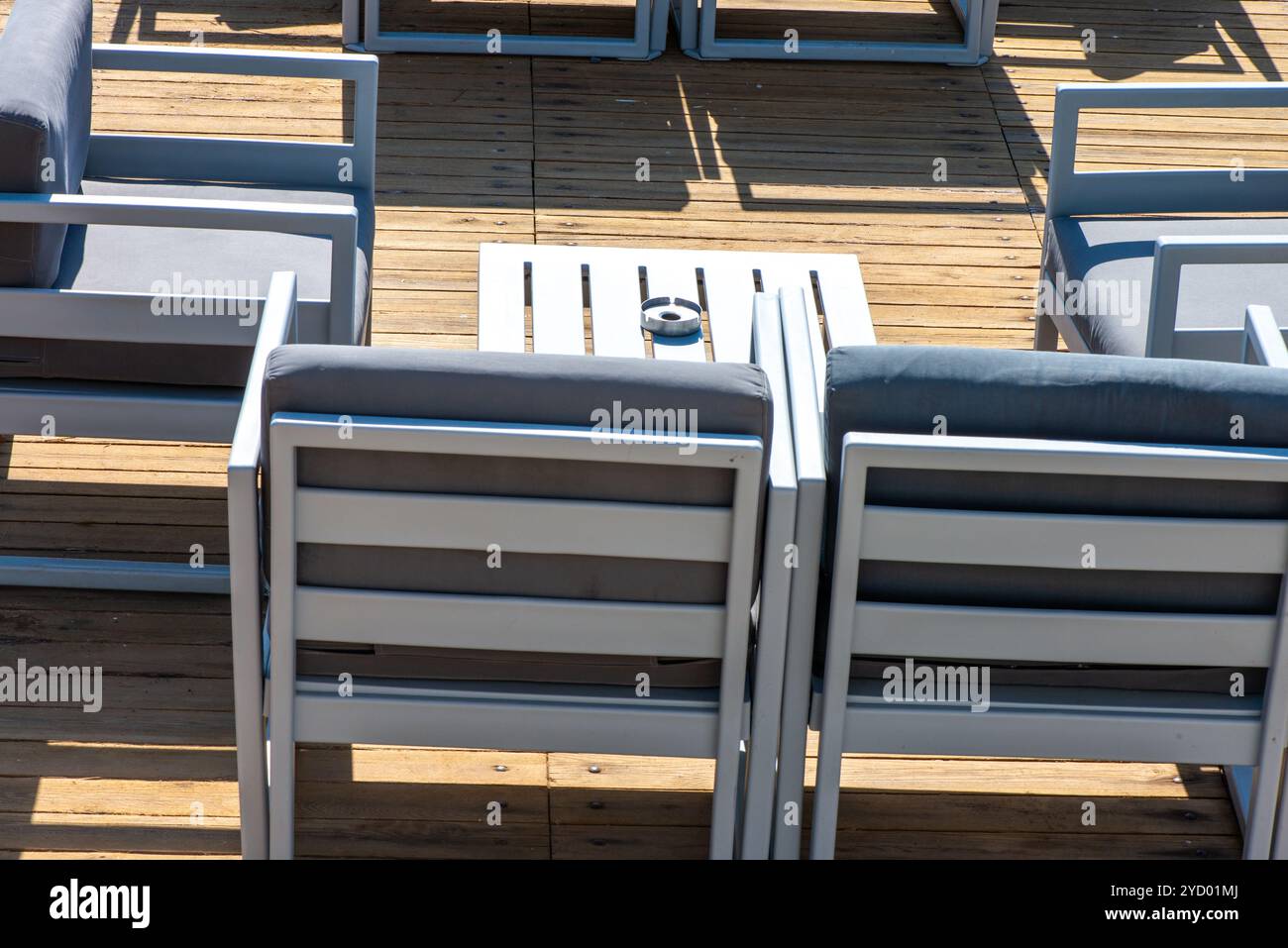 Sièges confortables et canapés disposés en bord de mer sous un ciel ensoleillé, offrant l'endroit idéal pour se détendre et profiter d'une vue imprenable sur l'océan. Banque D'Images