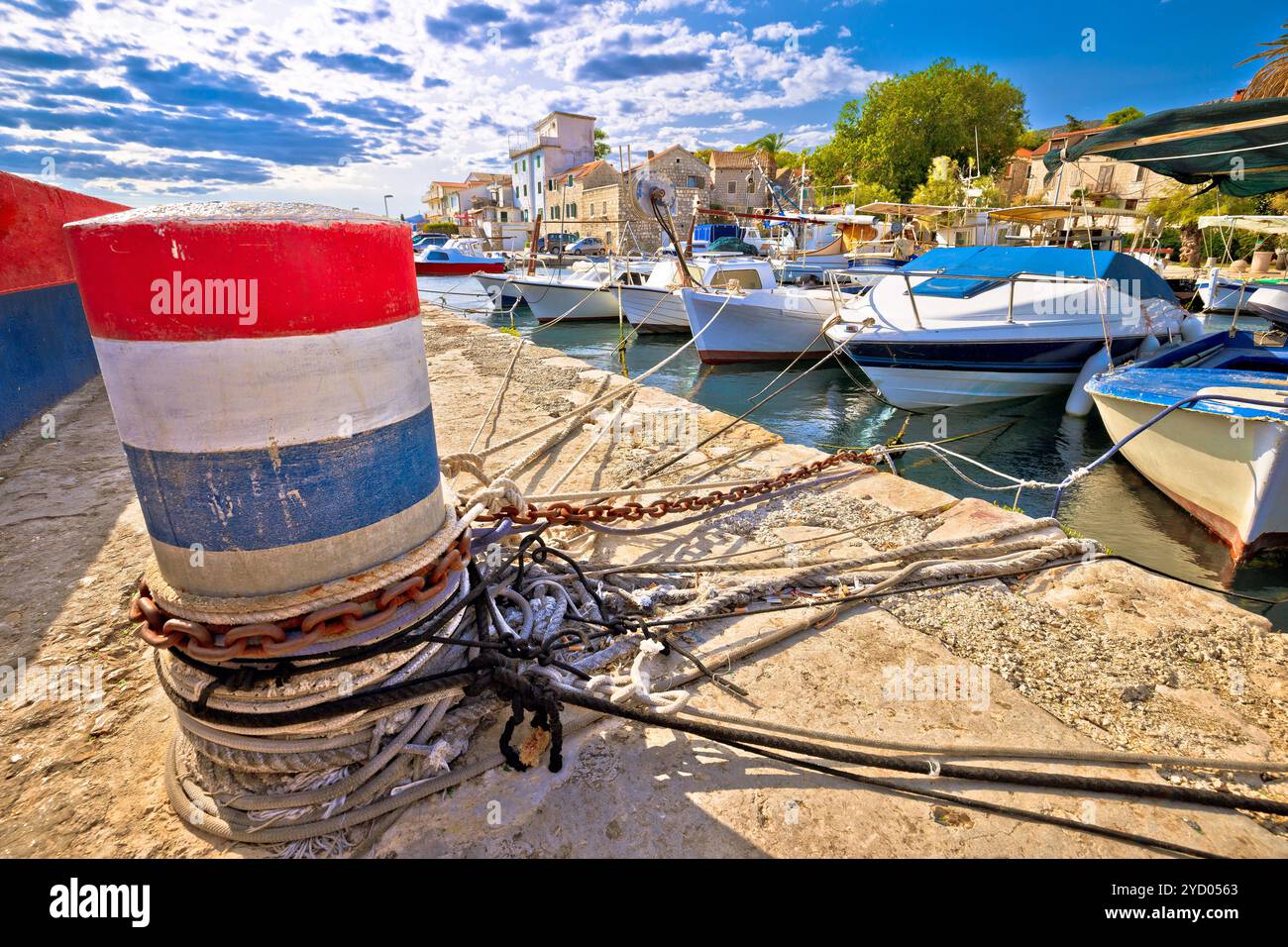 Borne d'amarrage et vieux bateaux dans le port de Kastela Banque D'Images
