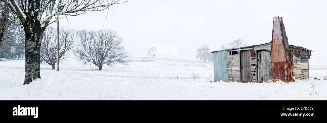 Cabane en bois rustique avec cheminée dans le paysage hivernal enneigé Banque D'Images