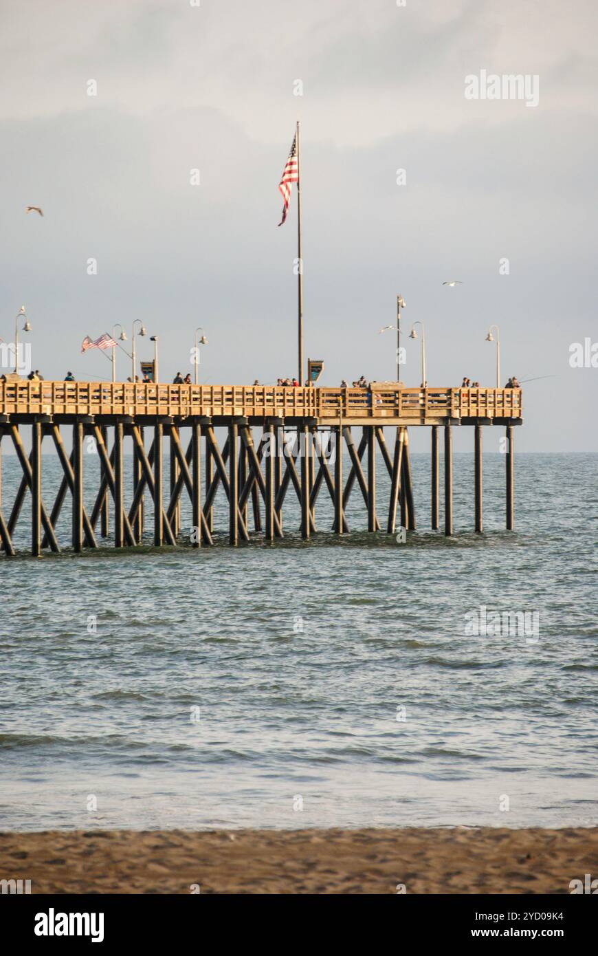 Les gens apprécient le beau coucher de soleil à Ventura Pier à Ventura, Californie. Prise de vue verticale Banque D'Images