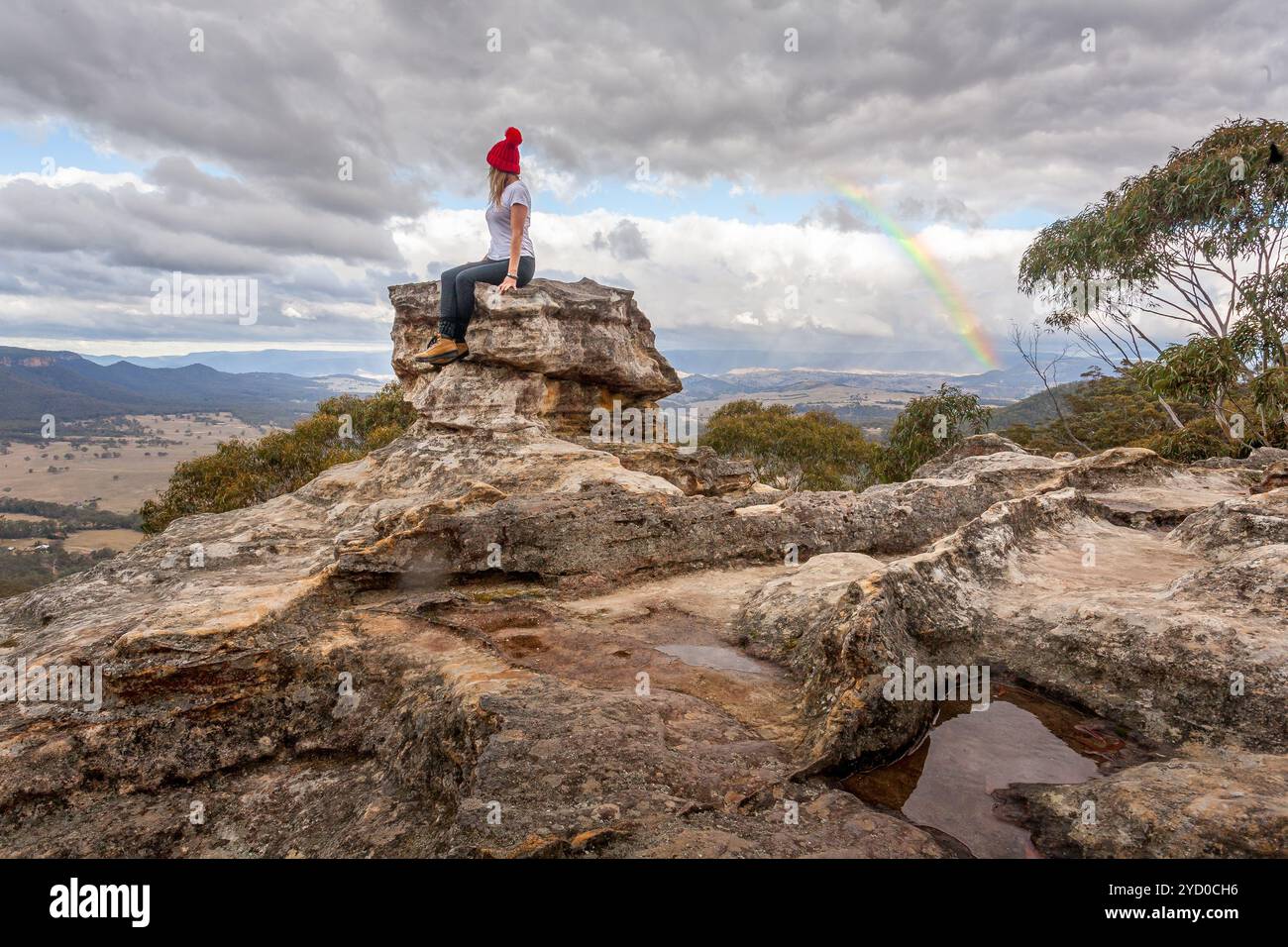 Femme perchée sur le pic de pilier rocheux avec les meilleures vues ci-dessous braver le froid de la montagne Banque D'Images