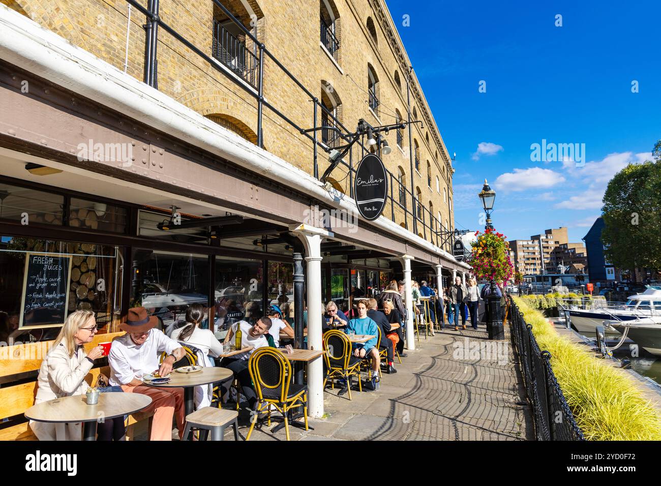 Les gens dînent en plein air dans les restaurants et cafés de St Katharine Docks, Londres, Angleterre Banque D'Images