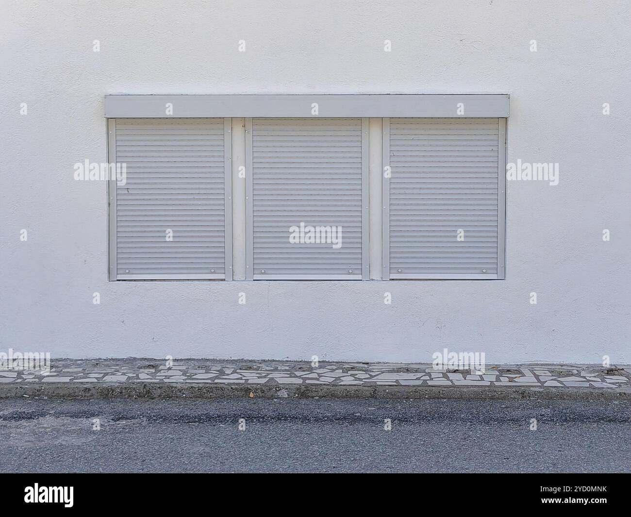 Minimalisme moderne : cadres de fenêtre triples avec stores blancs sur le mur donnant sur la rue Banque D'Images