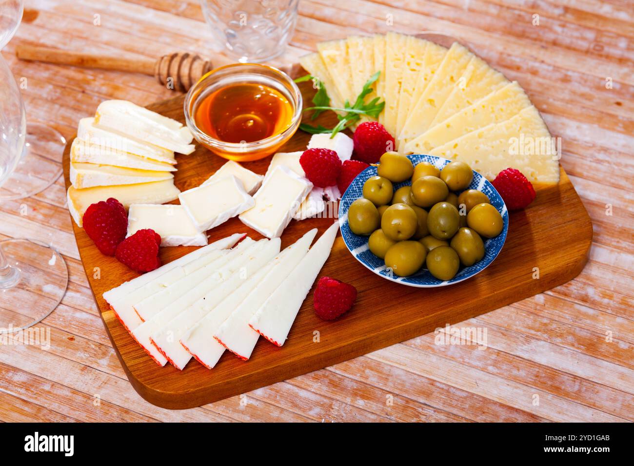 Assiette avec différents types de fromage, framboises et olives Banque D'Images