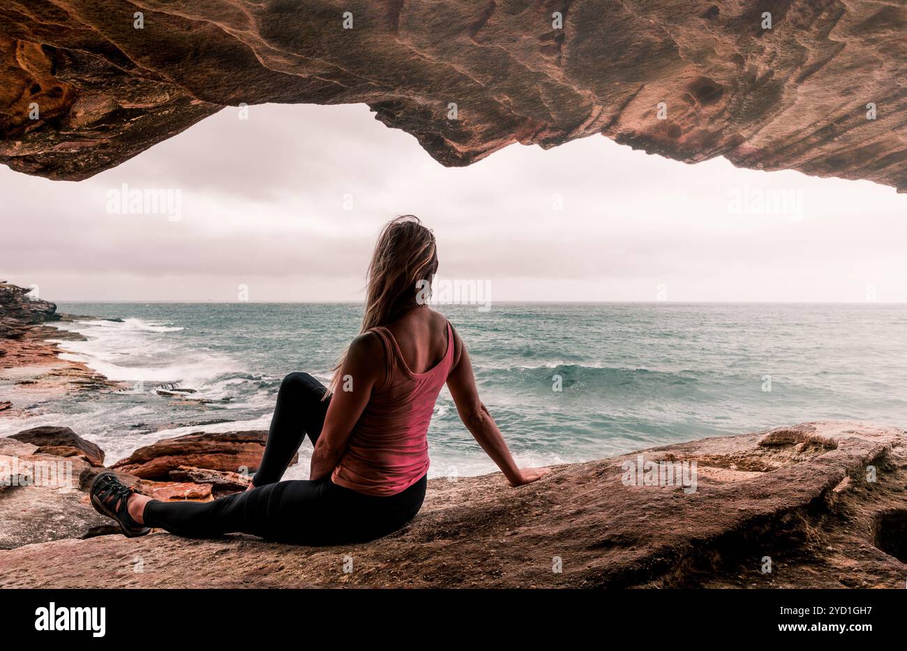 Femme en vêtements actifs assise près de l'océan Banque D'Images