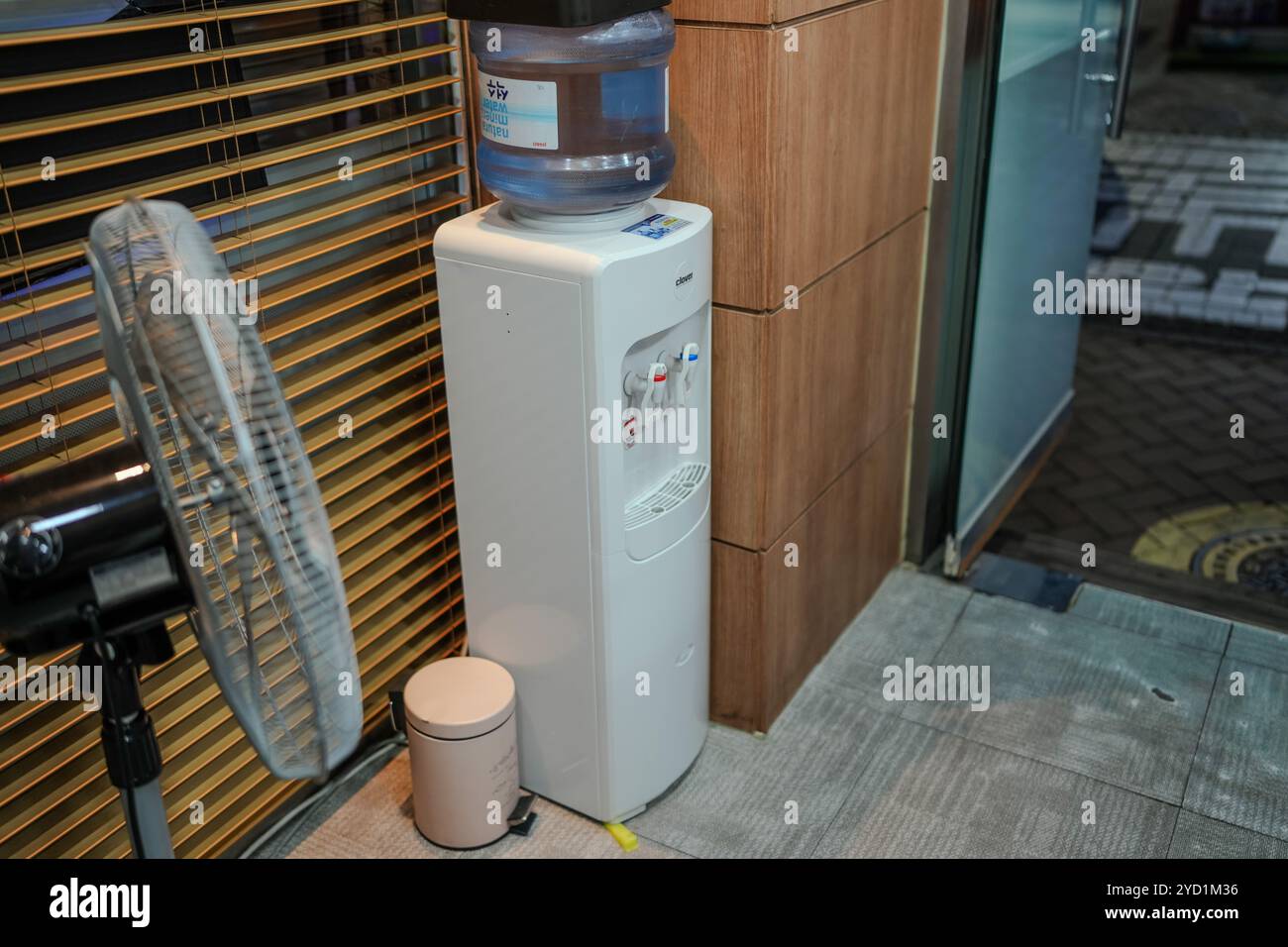 Refroidisseur d'eau blanche avec un couvercle bleu. Un ventilateur est à côté. Le ventilateur est éteint Banque D'Images