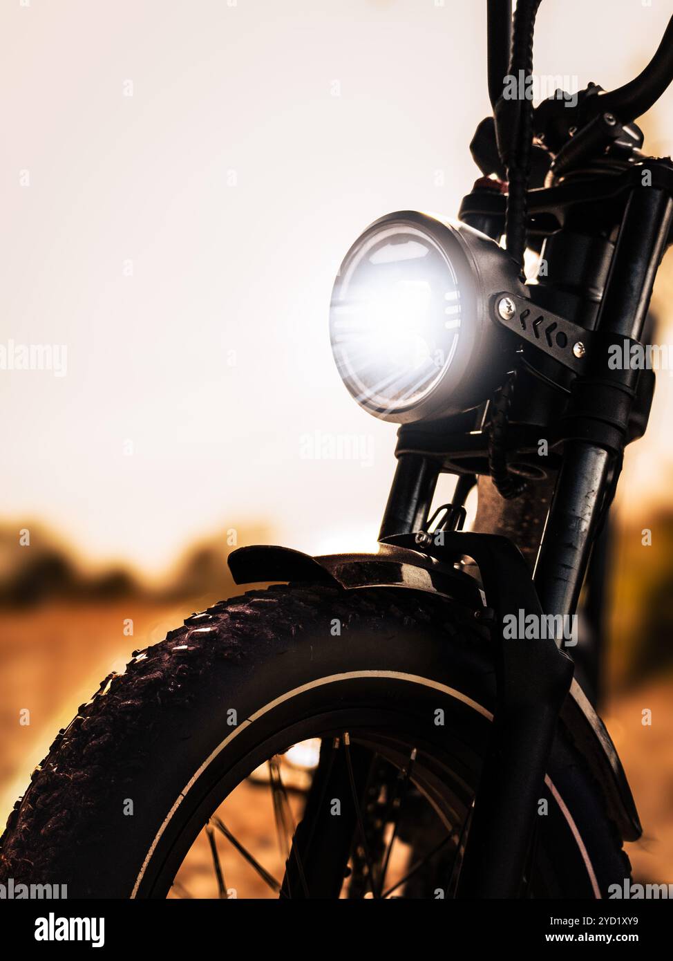 Vélo électrique sur route de terre en automne avec phare Banque D'Images