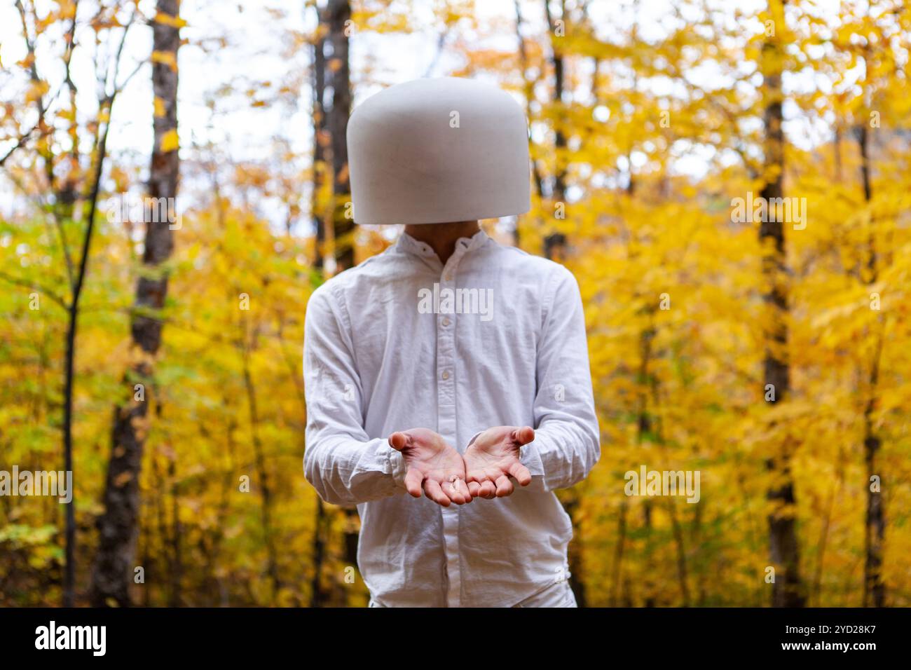 L'homme en blanc a un bol de cristal sur la tête tout en faisant preuve de générosité Banque D'Images