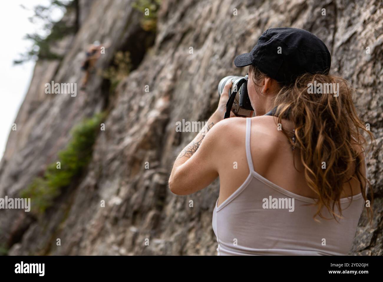 Un photographe sportif photographie un grimpeur Banque D'Images