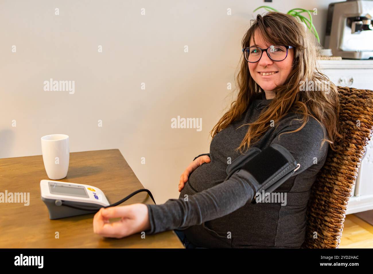 La femme enceinte utilise un tensiomètre Banque D'Images