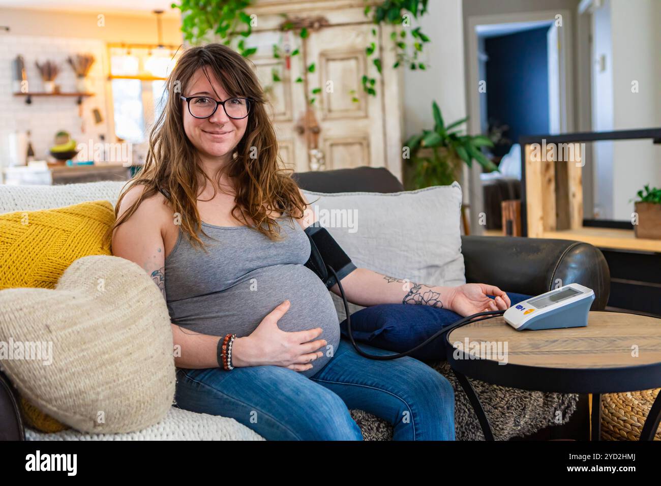 La femme enceinte utilise un tensiomètre Banque D'Images
