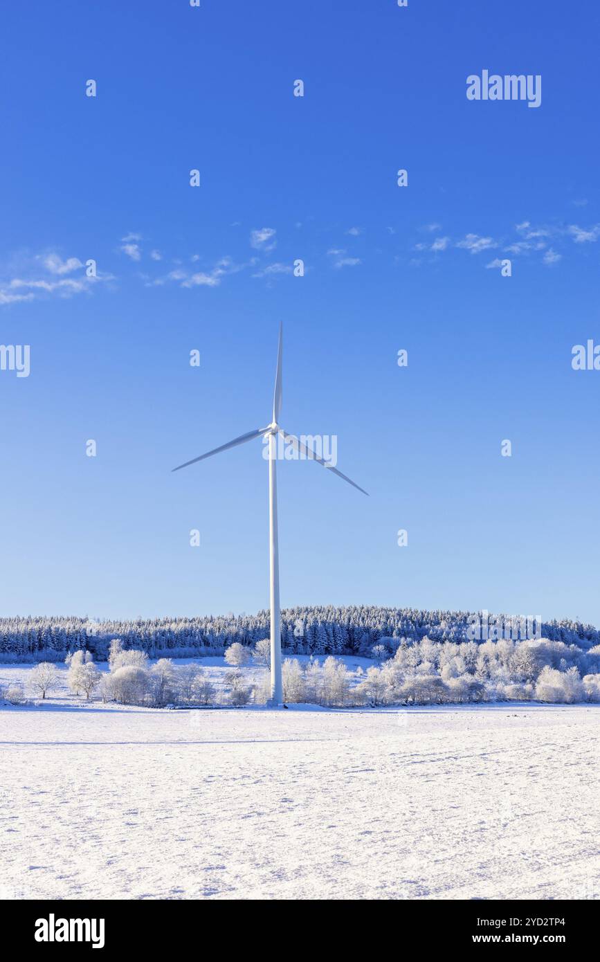 Éoliennes dans un champ dans un paysage hivernal froid et enneigé avec un ciel bleu clair, Suède, Europe Banque D'Images