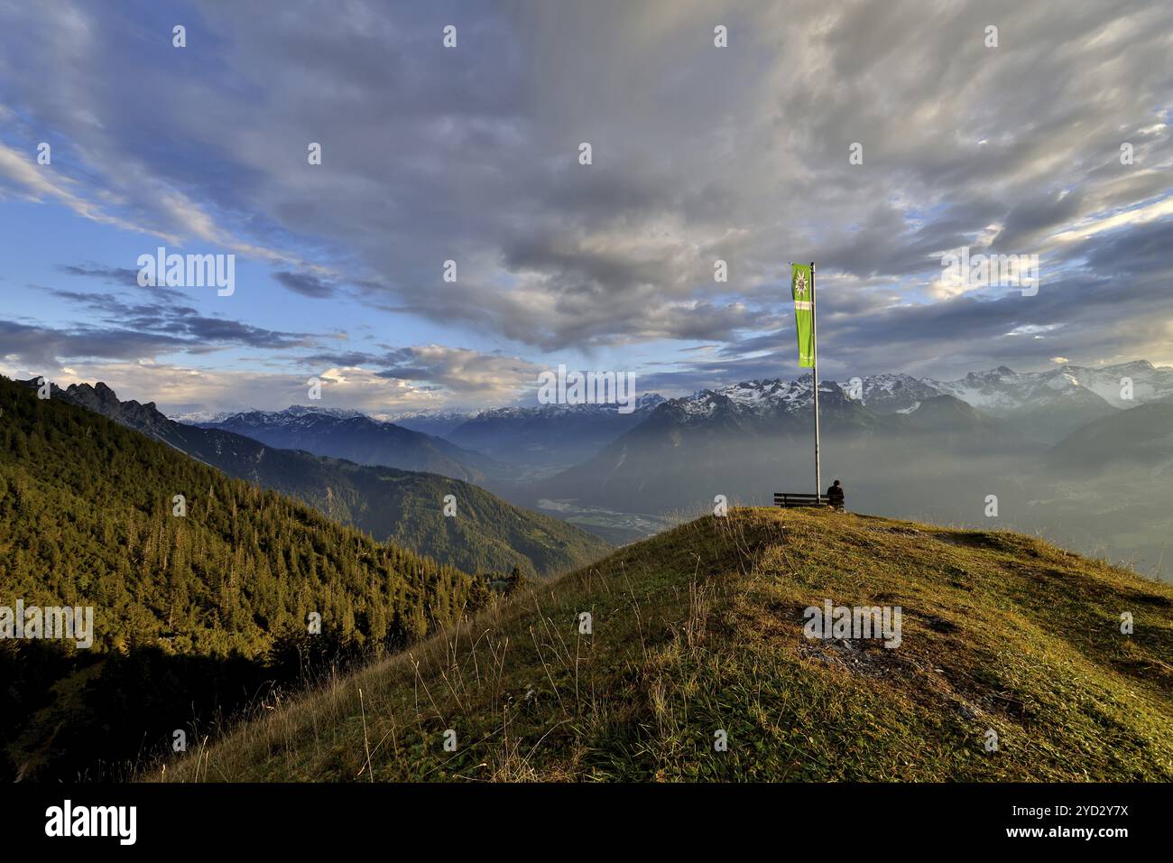 Femme assise jouissant d'une ambiance de soirée onirique dans les montagnes, vue sur le Raetikon, drapeau du Club alpin autrichien, Frassenhuette, Vorarlberg, A. Banque D'Images
