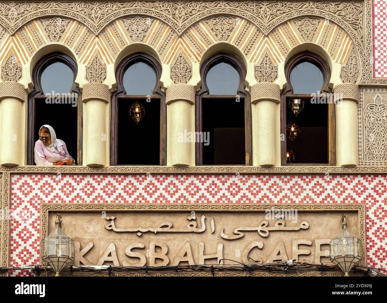 Marrakech, Maroc, 23 mars 2024 : femme musulmane observant la vie urbaine et regardant par la fenêtre du Kasbah Cafe au centre-ville de Marrakech, AF Banque D'Images