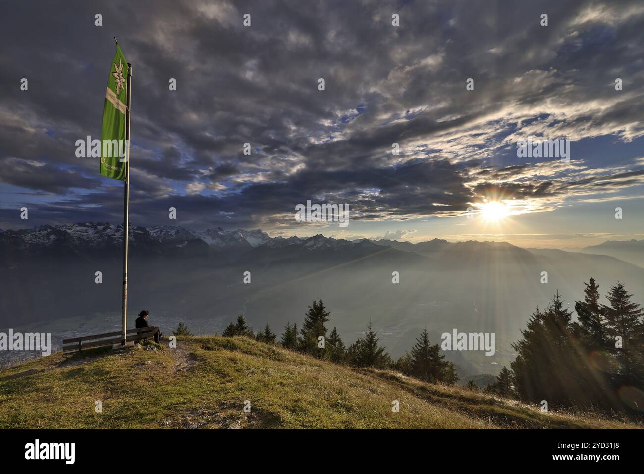 Femme assise jouissant d'une ambiance de soirée onirique dans les montagnes, coucher de soleil, vue sur le Raetikon, drapeau du Club alpin autrichien, Frassenhuette, Vorar Banque D'Images