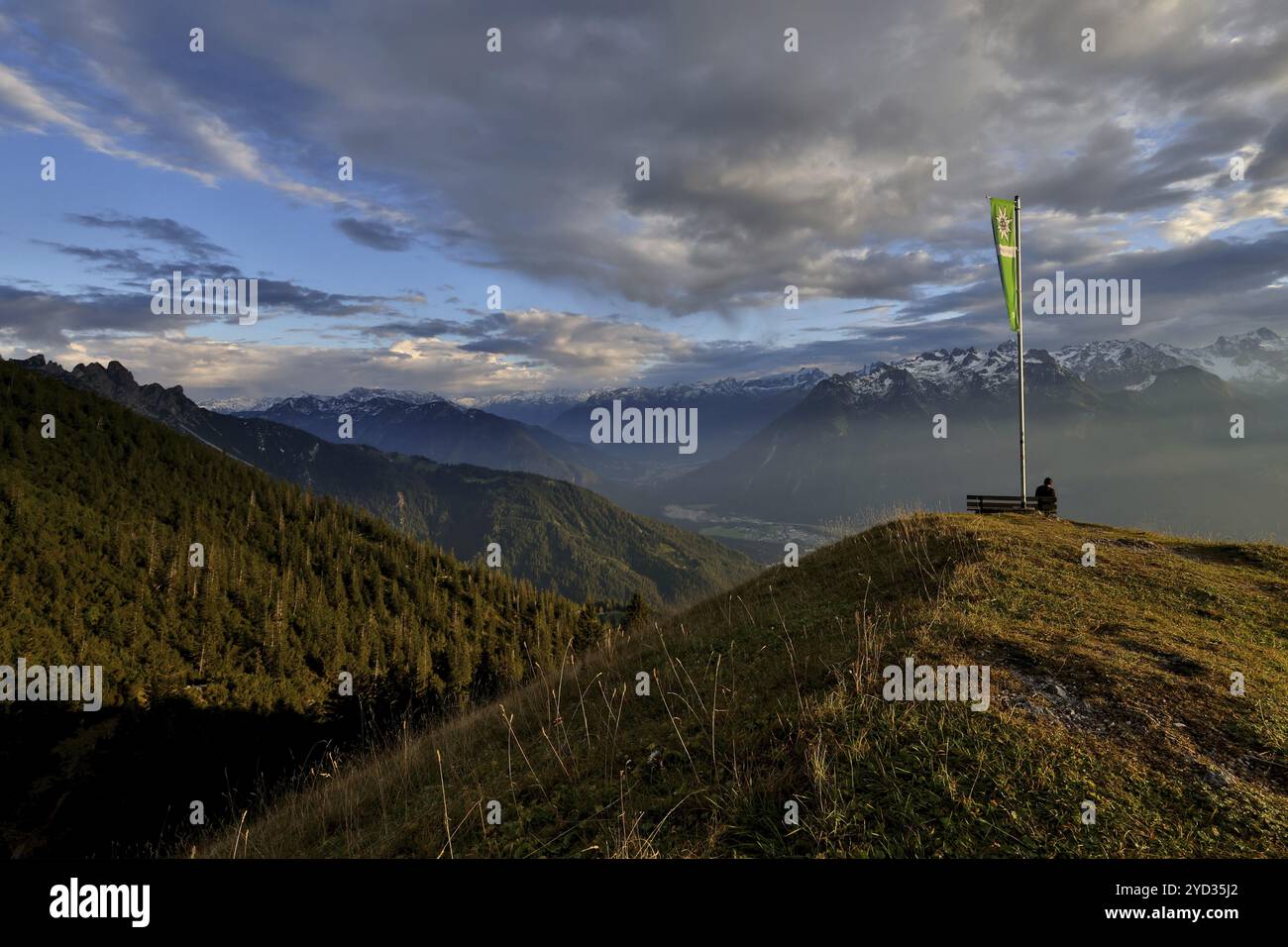 Femme assise jouissant d'une ambiance de soirée onirique dans les montagnes, vue sur le Raetikon, drapeau du Club alpin autrichien, Frassenhuette, Vorarlberg, A. Banque D'Images