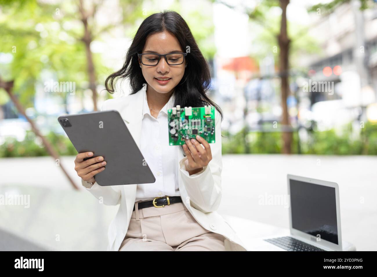 Femmes d'affaires ingénieur en matériel informatique. Concepteur de circuits imprimés en chef de projet examinant les cartes de circuits imprimés d'échantillon prêtes à la production de masse. Banque D'Images