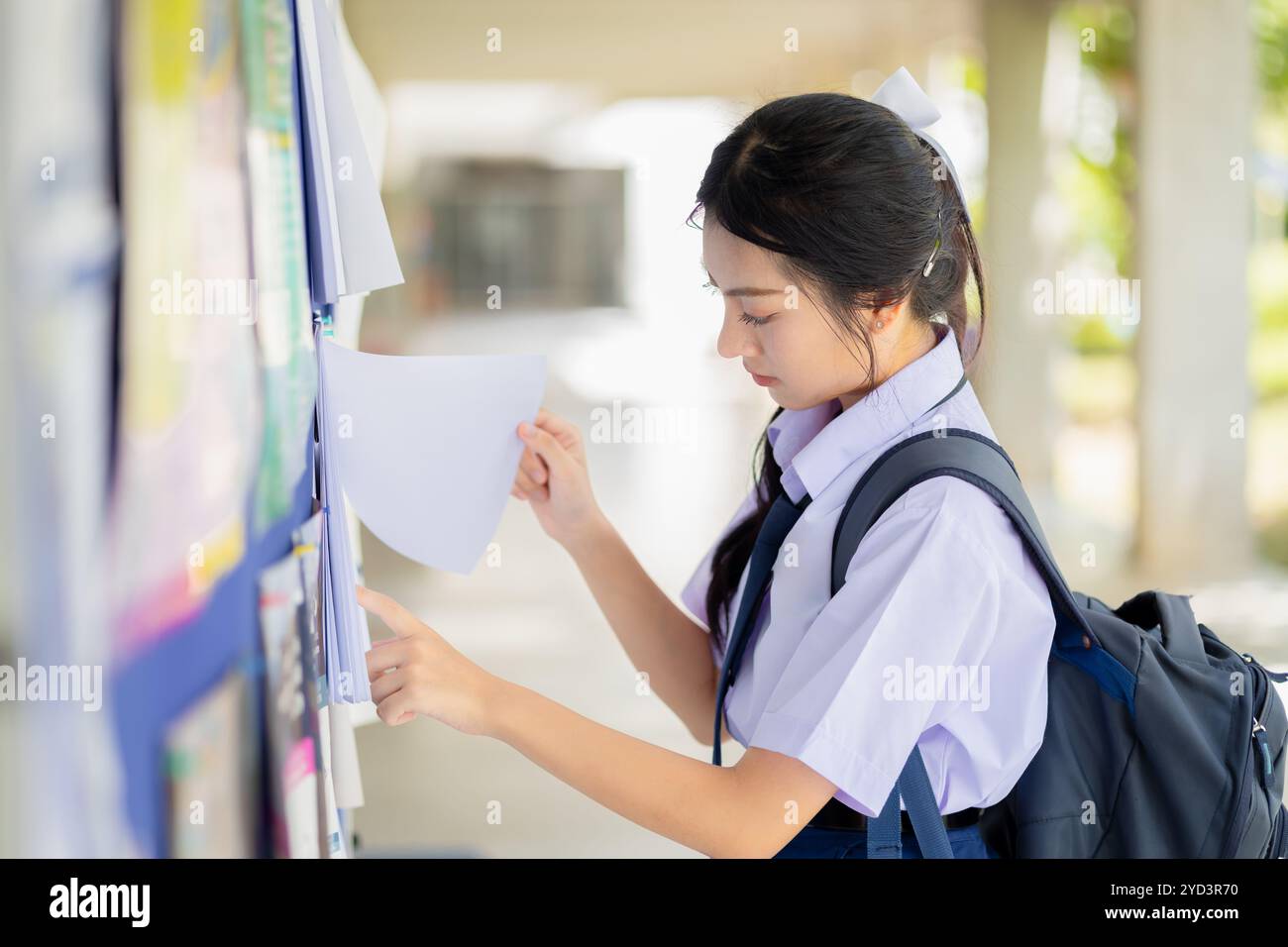 Message étudiant regardant au panneau d'affichage de l'école pour étudier l'annonce d'information, l'adolescent de l'école cherchant des emplois à temps partiel. Banque D'Images