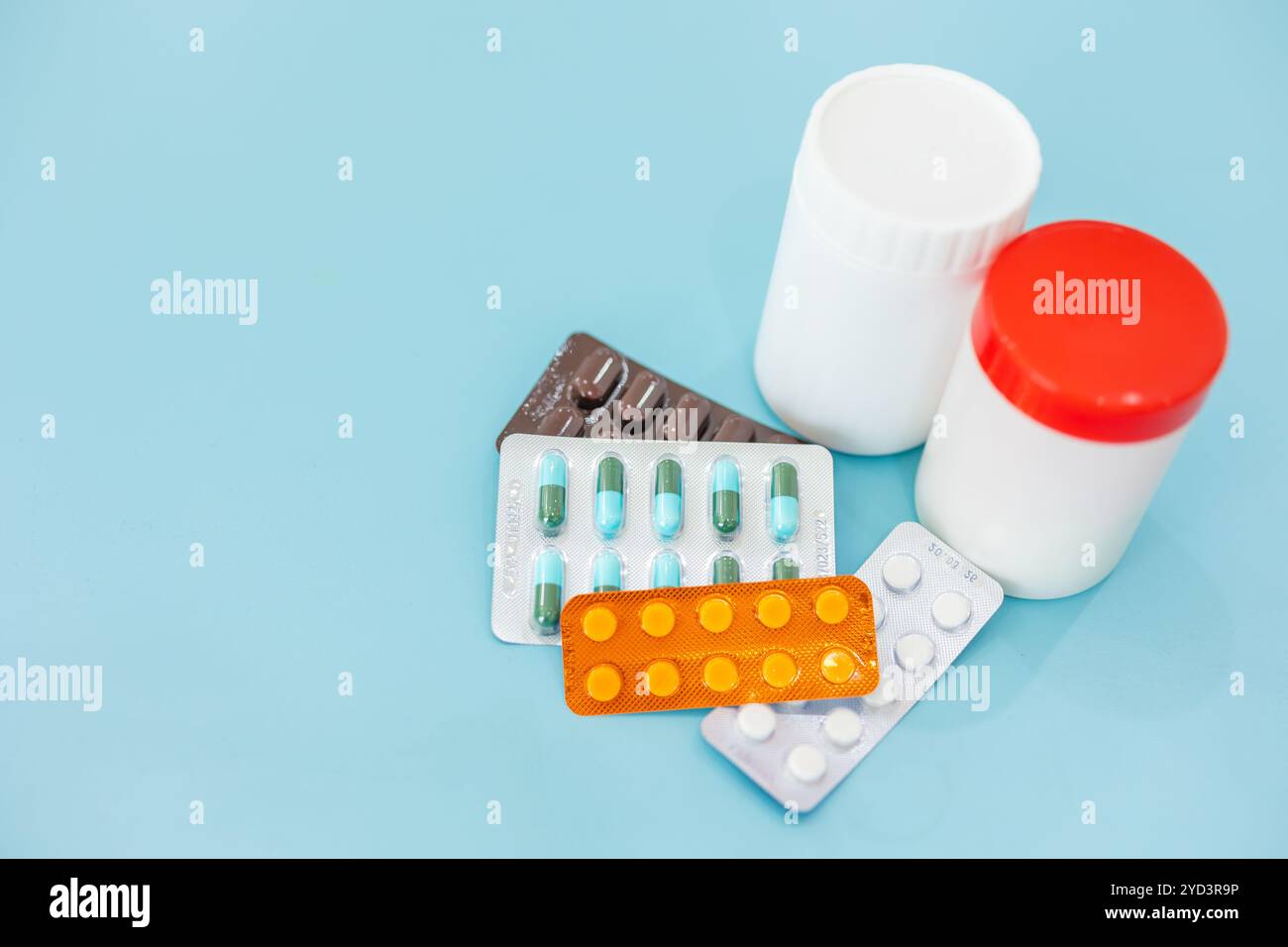 mélangez le type de pilules de bouchons de médecine et la capsule sur l'espace de copie blanc de fond de couleur bleu propre pour le texte, en utilisant la médecine pour le concept de soins de santé. Banque D'Images