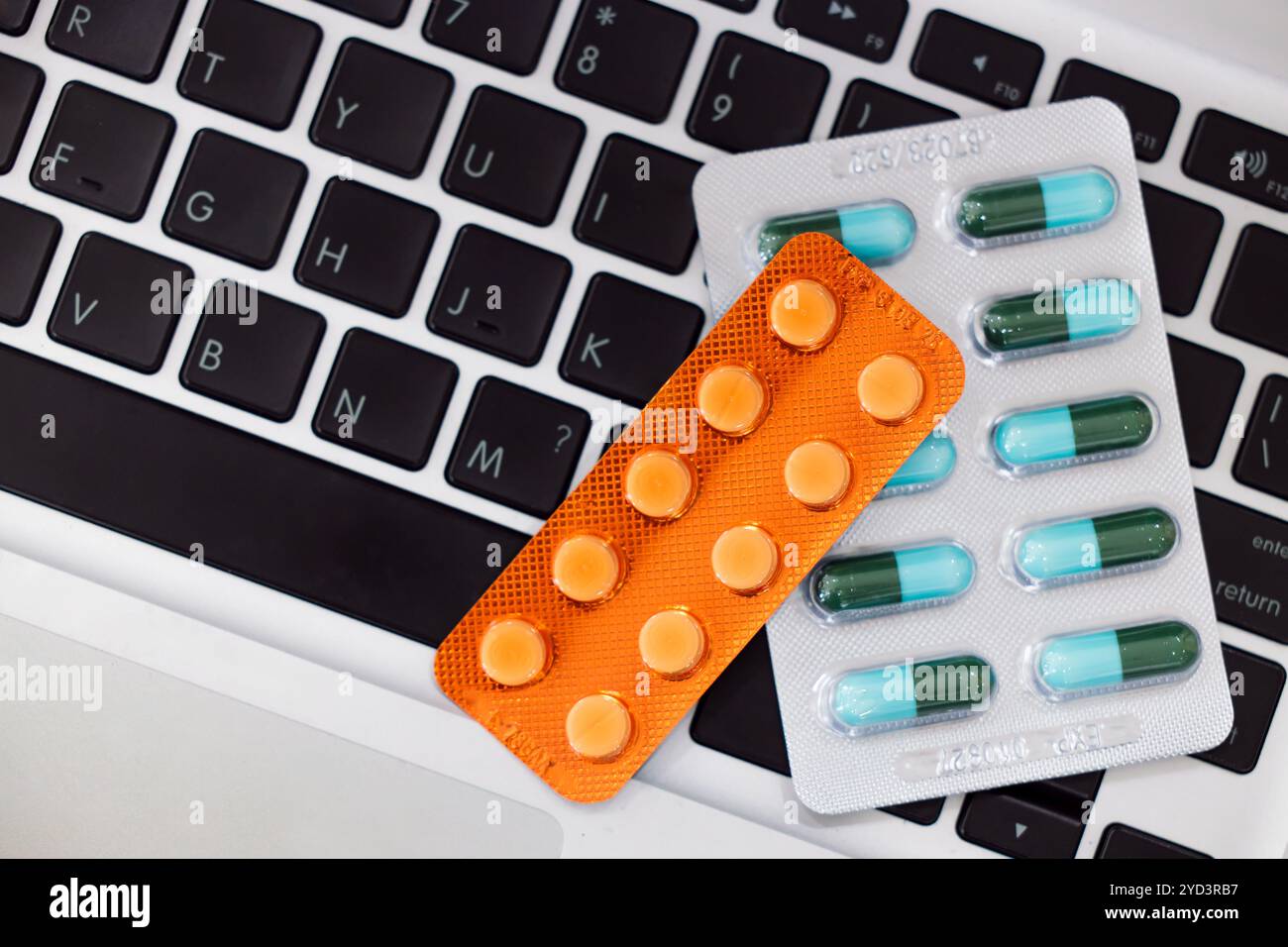 Pack de capsules de pilules de médicaments sur le clavier d'ordinateur portable, traitement médical du syndrome de bureau de travailler dur avec le concept d'ordinateur. Banque D'Images