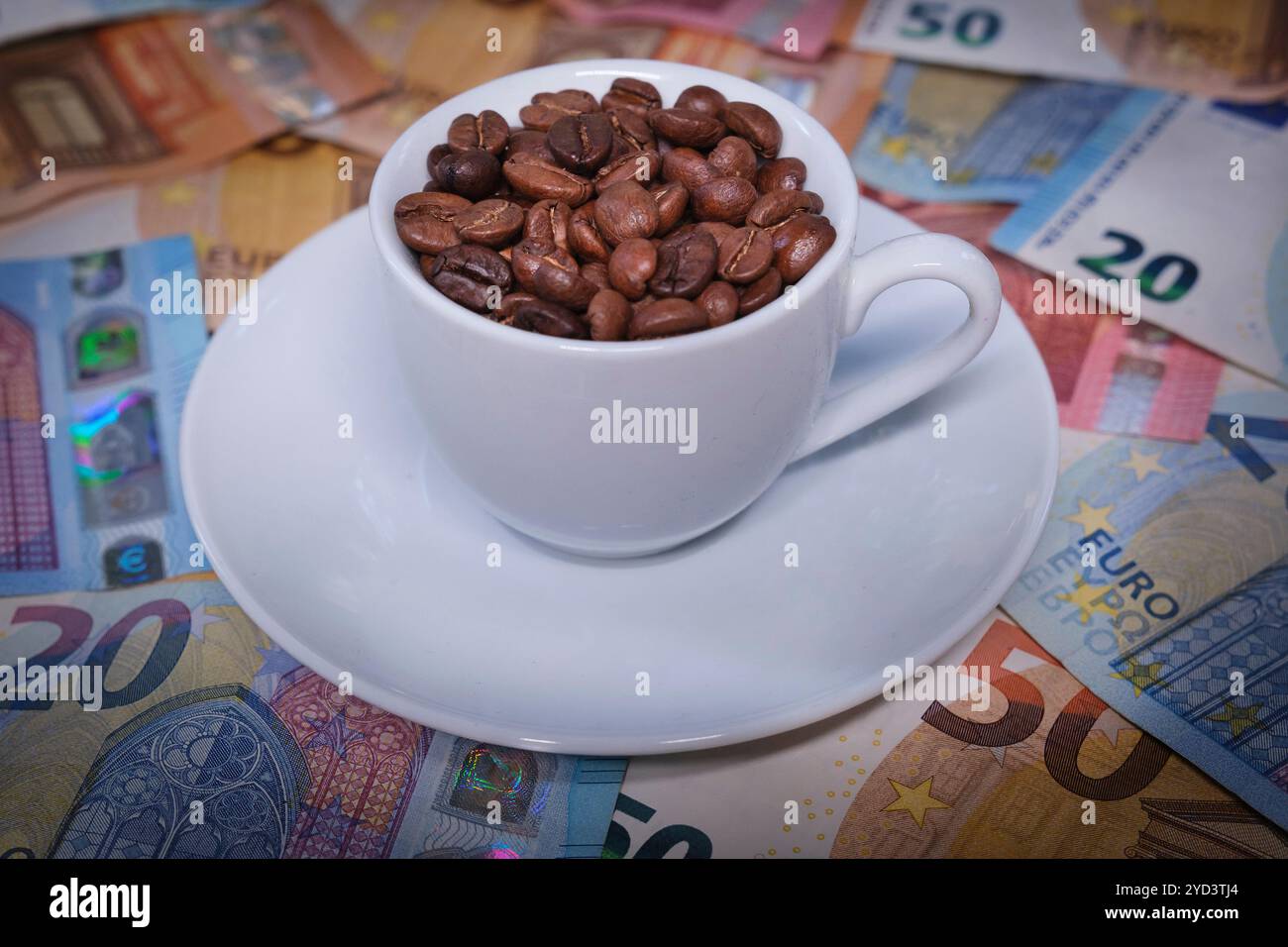 Tasse à espresso remplie de grains de café sur les billets en euros Banque D'Images