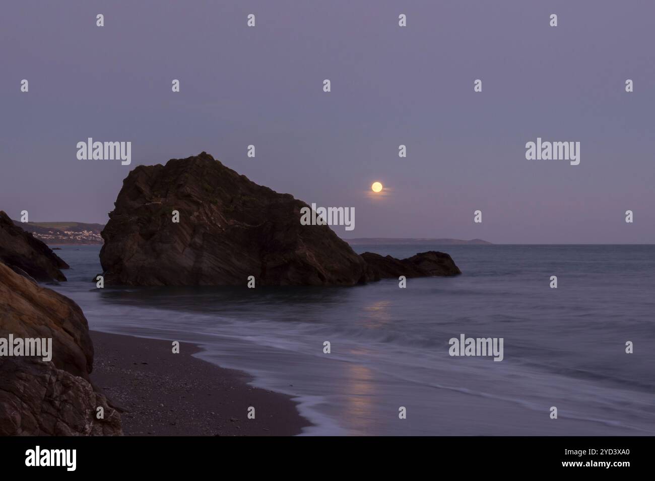 Lever de la lune vu à travers et au-dessus des rochers au bout de la plage de Plaidy près de Looe, Cornwall, Royaume-Uni, 17 septembre 2024, nuit avant Super Harvest Moon, Corn Moon Banque D'Images